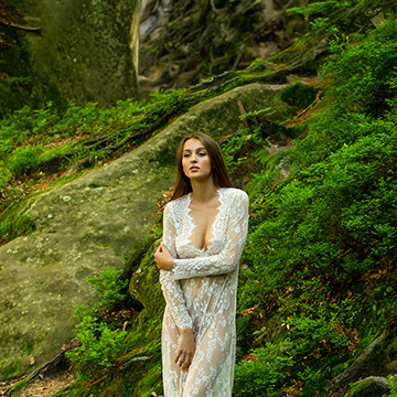 Boudoirfoto in der Natur. Eine Frau steht im Wald.