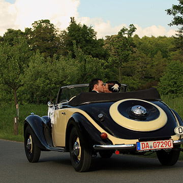 Das Brautpaar sitzt im Auto und küsst sich. Hochzeit in Weinheim