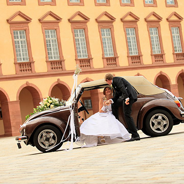 Das Brautpaar mit einem Oldtimer vor dem Schloss in Mannheim. Hochzeit in Mannheim
