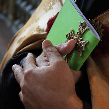 Der Priester hält an Kreuz bei der Trauung. Hochzeit in Baden-Baden.