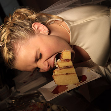 Die Braut versucht die Hochzeitstorte zu beissen. Hochzeit in Heidelberg.