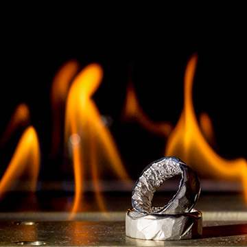 Die Hochzeitsringe liegen vor der Kaminfeuer. Hochzeitsfoto